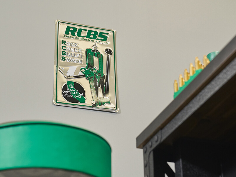 RCBS Metal Sign on wall next to reloading bench